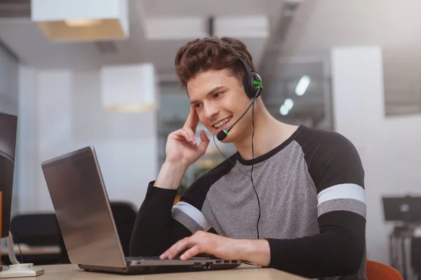 Freundlicher Kundenbetreuer mit Headset, das auf Abruf arbeitet — Stockfoto