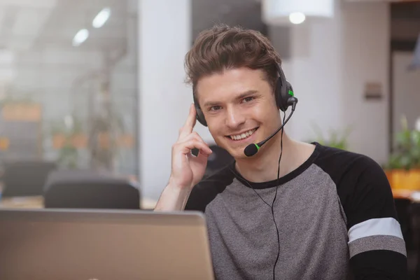 Freundlicher Kundenbetreuer mit Headset, das auf Abruf arbeitet — Stockfoto