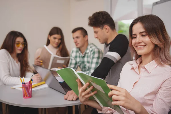 Group of young people studying together at college classroom