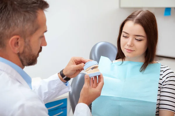 Urocza Młoda Kobieta Odwiedzająca Dentystę Dojrzałe Mężczyzna Dentysta Pokazując Jego — Zdjęcie stockowe