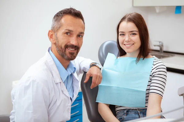 Przystojny Dojrzały Dentysta Jego Urocza Pacjentka Uśmiechnięta Aparatu Badaniu Lekarskim — Zdjęcie stockowe