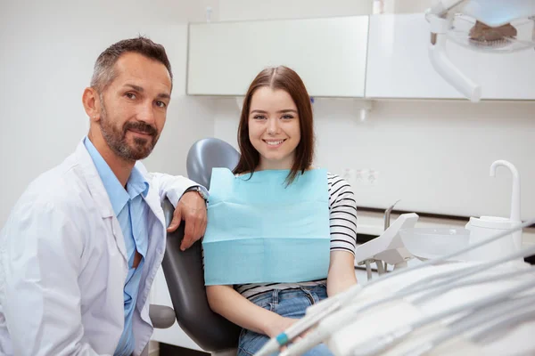 Jovem Atraente Sentada Uma Cadeira Dentária Lado Seu Dentista Espaço — Fotografia de Stock