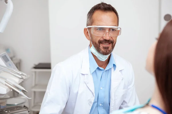 Wesoły Dojrzały Dentysta Uśmiecha Się Podczas Rozmowy Pacjentką Badaniu Stomatologicznym — Zdjęcie stockowe