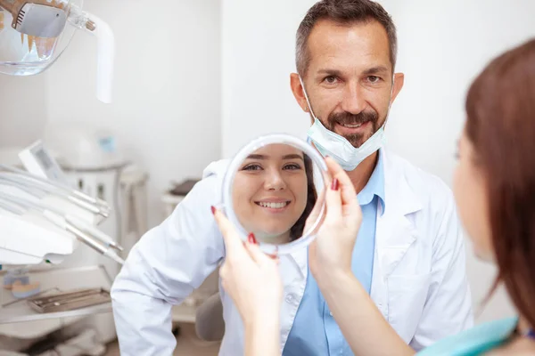 Alegre Dentista Masculino Maduro Sonriendo Cámara Paciente Hembra Comprobando Sus —  Fotos de Stock