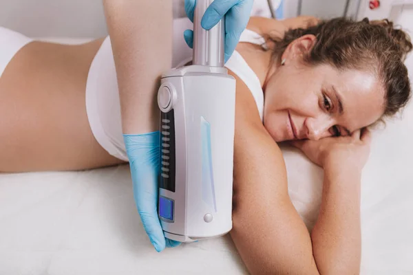 拍摄了一个快乐的成熟女人在温泉中心接受子宫内膜治疗的照片 美容师在女性病人的胳膊上使用胚乳按摩器 — 图库照片
