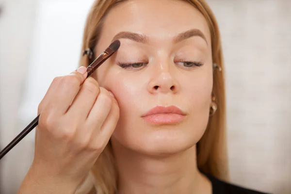 Artista Maquiagem Profissional Aplicando Base Sombra Nas Pálpebras Uma Cliente — Fotografia de Stock