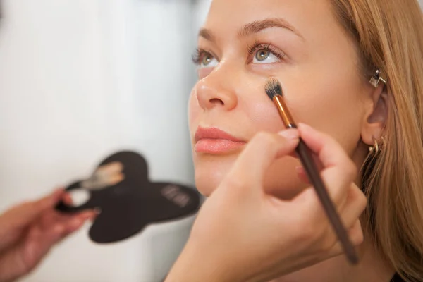 Primer Plano Una Hermosa Mujer Sonriendo Mientras Artista Maquillaje Profesional — Foto de Stock