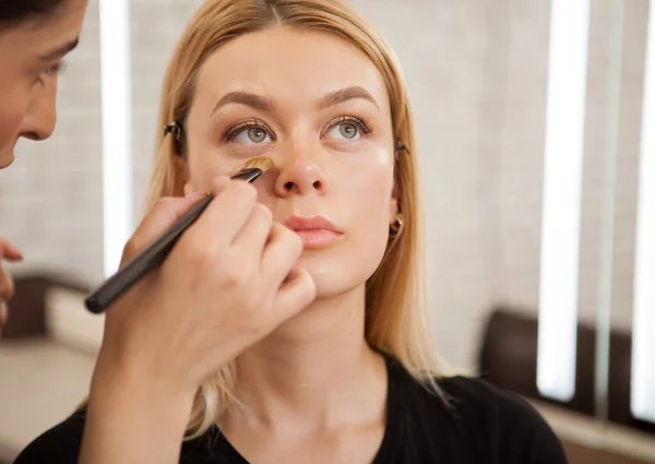 Artista Maquiagem Profissional Aplicando Corretor Sob Olhos Uma Bela Cliente — Fotografia de Stock