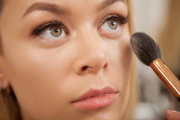 Recortado Primer Plano Artista Maquillaje Profesional Aplicando Resaltador Cara Mujer — Foto de Stock