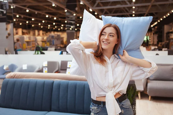 快乐的年轻女人喜欢在家具店里买枕头 — 图库照片
