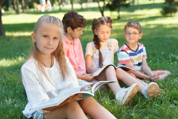 Υπέροχο Κοριτσάκι Που Διαβάζει Ένα Βιβλίο Στο Πάρκο Φίλοι Της — Φωτογραφία Αρχείου
