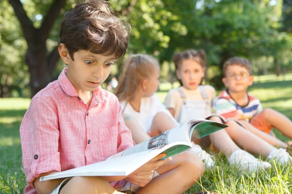 Cute Little Boy Looking Overwhelmed Reading Book Public Park — Stock Photo, Image