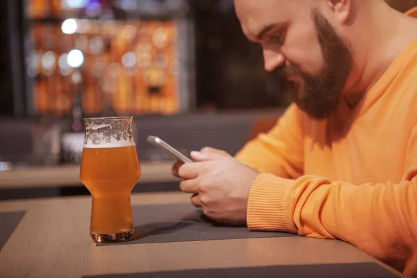 Barda Bir Bardak Bira Içerken Akıllı Telefonuyla Mesajlaşan Bir Adamın — Stok fotoğraf
