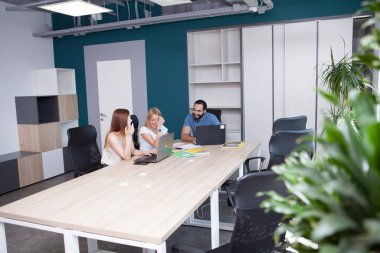 Neşeli meslektaşlar bir projede birlikte çalışmaktan zevk alıyorlar.