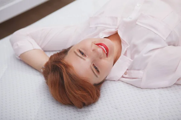 一个喜欢躺在骨科床垫上的快乐而轻松的女人的头像特写 — 图库照片