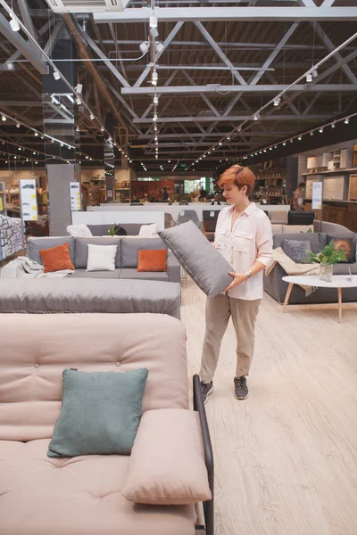 一个女顾客检查沙发垫子 在家具店购物的垂直照片 — 图库照片