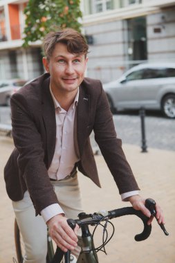 İşe bisikletle giden çekici bir iş adamının dikey kesilmiş portresi.