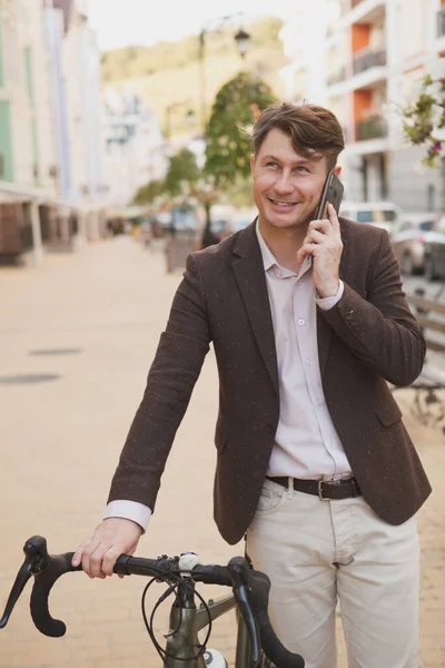 자전거를 거리를 남자가 전화로 이야기하고 모습의 — 스톡 사진