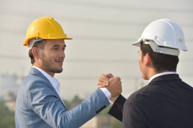 Güvenilirlik ortaklık ve işbirliği kavramı. iş. İyi bir anlaşma. Çalışma evinde otururken el sıkışan iki iş adamları kapatın. Mühendis ve mimar büyük bir proje üzerinde çalışmak için güçlerini birleştirmeleri.