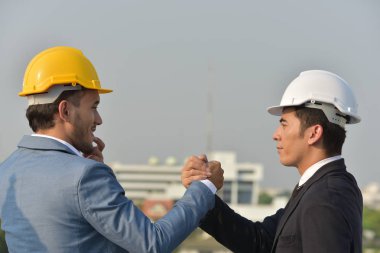 Güvenilirlik ortaklık ve işbirliği kavramı. iş. İyi bir anlaşma. Çalışma evinde otururken el sıkışan iki iş adamları kapatın. Mühendis ve mimar büyük bir proje üzerinde çalışmak için güçlerini birleştirmeleri.