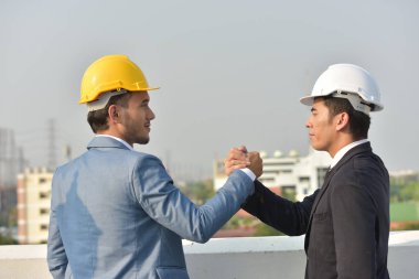 Güvenilirlik ortaklık ve işbirliği kavramı. iş. İyi bir anlaşma. Çalışma evinde otururken el sıkışan iki iş adamları kapatın. Mühendis ve mimar büyük bir proje üzerinde çalışmak için güçlerini birleştirmeleri.
