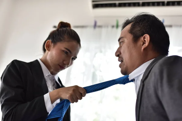 Conflict in the workplace Female employees are pulling the tie of male employees. Express anger and use force