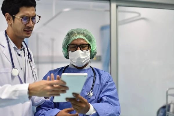 Photos of doctors in work uniforms Doctor consulted about the patient's case in the emergency room.