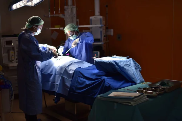 Medical Team Performing Surgical Operation in Modern Operating Room. Equipment and medical devices in hybrid operating room.scrub nurse preparing medical instruments for operation.