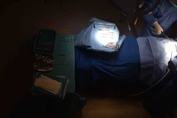 Medical Team Performing Surgical Operation in Modern Operating Room. Equipment and medical devices in hybrid operating room.scrub nurse preparing medical instruments for operation.