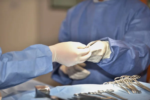 Medical Team Performing Surgical Operation in Modern Operating Room. Equipment and medical devices in hybrid operating room.scrub nurse preparing medical instruments for operation.