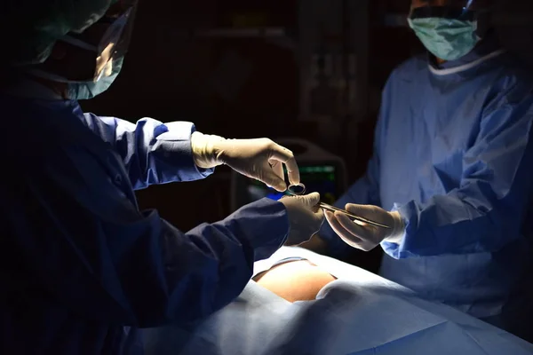 Medical Team Performing Surgical Operation in Modern Operating Room. Equipment and medical devices in hybrid operating room.scrub nurse preparing medical instruments for operation.