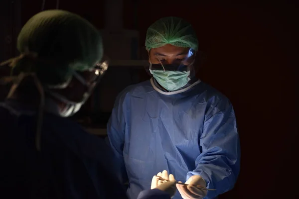 Medical Team Performing Surgical Operation in Modern Operating Room. Equipment and medical devices in hybrid operating room.scrub nurse preparing medical instruments for operation.