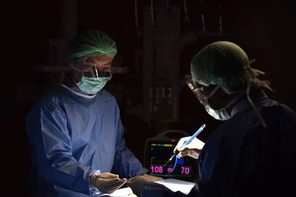 Medical Team Performing Surgical Operation in Modern Operating Room. Equipment and medical devices in hybrid operating room.scrub nurse preparing medical instruments for operation.