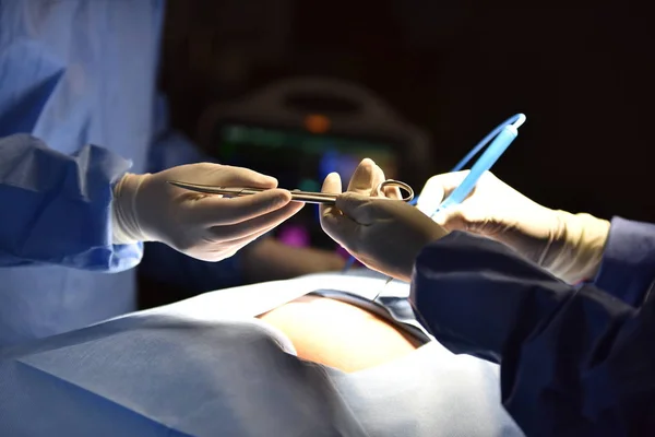 Medical Team Performing Surgical Operation in Modern Operating Room. Equipment and medical devices in hybrid operating room.scrub nurse preparing medical instruments for operation.