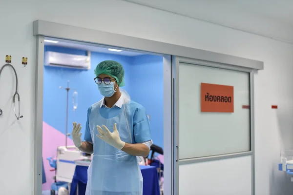 Team surgeon at work in operating room. Surgical light in the operating room. Preparation for the beginning of surgical operation with a cut. The surgeon is performing surgery on the patient.