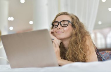 Genç Seksi güzel ve mutlu kadın portresi ben dizüstü kullanma ve yalan bikini. Güzellik kadını çekici ile gülümseme ve sağlık cilt ve saç, tatlı bir gülümsemeyle kadınla güzel bir şey göstermek. 