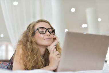 Genç Seksi güzel ve mutlu kadın portresi ben dizüstü kullanma ve yalan bikini. Güzellik kadın çekici ile gülümse ve size sağlık cilt ve saç, güzel kadın tatlı bir gülümseme ile bir şey göstereyim. Bir dizüstü bilgisayar kullanarak uyku, iş kontrol
