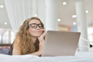Genç Seksi güzel ve mutlu kadın portresi ben dizüstü kullanma ve yalan bikini. Güzellik kadını çekici ile gülümseme ve sağlık cilt ve saç, tatlı bir gülümsemeyle kadınla güzel bir şey göstermek. 