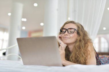 Genç Seksi güzel ve mutlu kadın portresi ben dizüstü kullanma ve yalan bikini. Güzellik kadını çekici ile gülümseme ve sağlık cilt ve saç, tatlı bir gülümsemeyle kadınla güzel bir şey göstermek. 