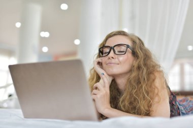 Genç Seksi güzel ve mutlu kadın portresi ben dizüstü kullanma ve yalan bikini. Güzellik kadın çekici ile gülümse ve size sağlık cilt ve saç, güzel kadın tatlı bir gülümseme ile bir şey göstereyim. Bir dizüstü bilgisayar kullanarak uyku, iş kontrol