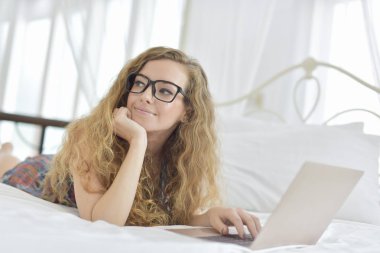 Genç Seksi güzel ve mutlu kadın portresi ben dizüstü kullanma ve yalan bikini. Güzellik kadını çekici ile gülümseme ve sağlık cilt ve saç, tatlı bir gülümsemeyle kadınla güzel bir şey göstermek. 