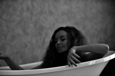 Bathtub.relaxed zamanında banyo döşeme genç bir kadın portresi. Güzel kadın. Güzel bir kızın beyaz pijamalı portre rahatlatıcı ile rahat bir tatil