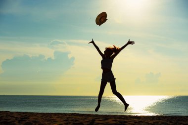 Genç çift egzersiz ve sabah erken sunrise plajda atlamak. Güzel sarı gökyüzü ile