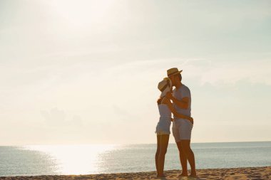 Genç çift egzersiz ve sabah erken sunrise plajda atlamak. Güzel sarı gökyüzü ile