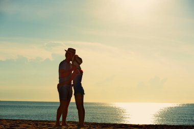 Genç çift egzersiz ve sabah erken sunrise plajda atlamak. Güzel sarı gökyüzü ile