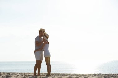 Genç çift egzersiz ve sabah erken sunrise plajda atlamak. Güzel sarı gökyüzü ile