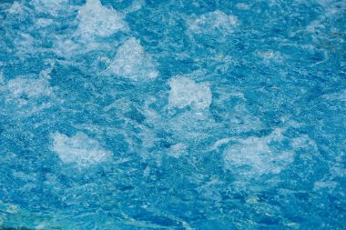 Yüzme havuzunun mavi suyundaki dalgalar