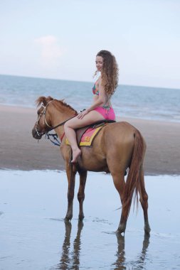 Güzel model mayo altında. Akşam plajda eğlenmek. Fotoğraflar güzel kadınların mayo beach.beautiful kadınlar ve atları plajda yürüyor