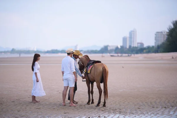 浪漫的情侣在下午的沙滩上骑马 在一个甜蜜的假期 年轻夫妇在清晨的日出时分在沙滩上锻炼和跳跃 美丽的黄色天空 — 图库照片