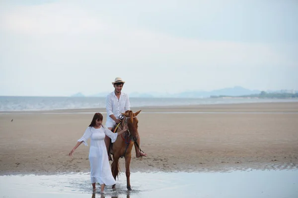 Romantic Couple With horse riding At the beach in the afternoon On a sweet holiday